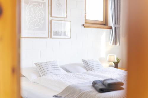 a white bed with two pillows on top of it at Chasa Fabulusa in Ftan