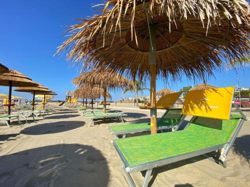 a group of chairs and umbrellas on a beach at Flamingo Suites in Marina di Camerota