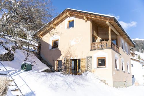 a house with a balcony in the snow at Chasa Fabulusa in Ftan
