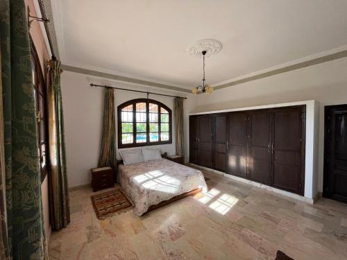 una camera con letto e finestra di Tiguimi Vacances - Oasis Villas, cadre naturel et vue montagne ad Agadir