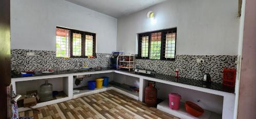 a kitchen with a sink and two windows at 'Marari Johns Homestay' Mararikulam, Alappuzha in Alleppey