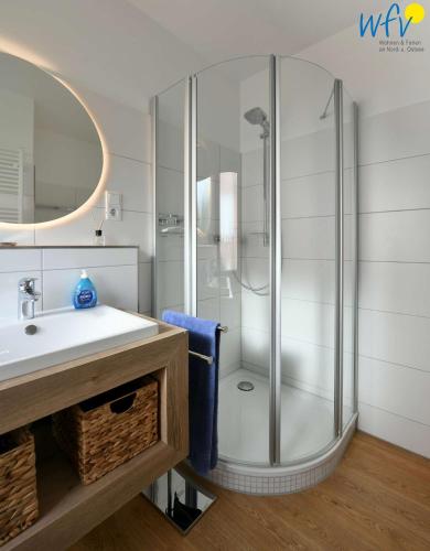 a bathroom with a shower and a white sink at Bungalow Hasela mit Workation in Juist