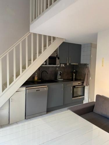 une cuisine avec des appareils en acier inoxydable et un escalier dans l'établissement Argeles plage, à Argelès-sur-Mer
