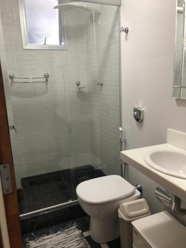 a bathroom with a shower and a toilet and a sink at gaivotas com ar condicionado in Guarapari