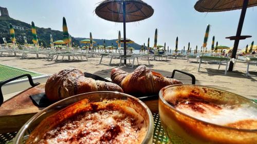 a table with food on a table with a beach at Flamingo Suites in Marina di Camerota
