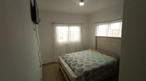 Dormitorio pequeño con cama y TV en Chelsie 2, en Bayahibe