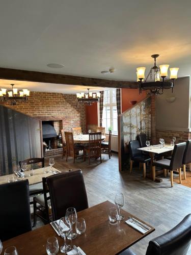 a restaurant with tables and chairs and a fireplace at The Ardingly Inn in Ardingly