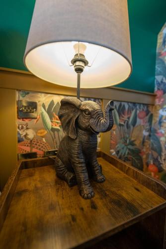a small elephant statue sitting on a table under a lamp at Kip 23 JJs Emsworth in Emsworth