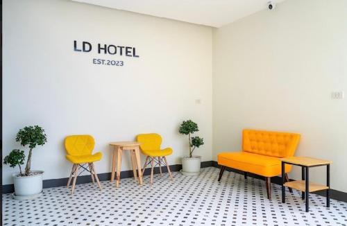 a room with three chairs and tables and plants at แอ่ว-ดีLD Hotel&Residences in Ngao