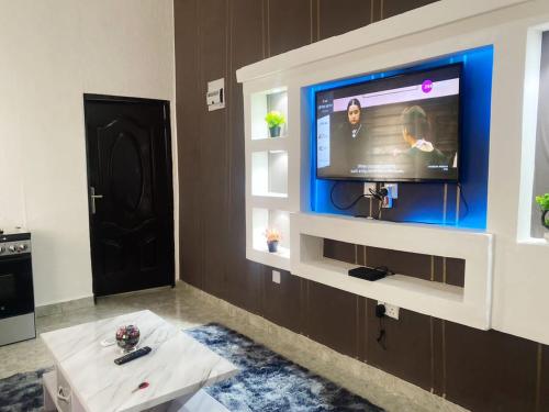 a living room with a flat screen tv on a wall at Shepherds Garden in Abuja