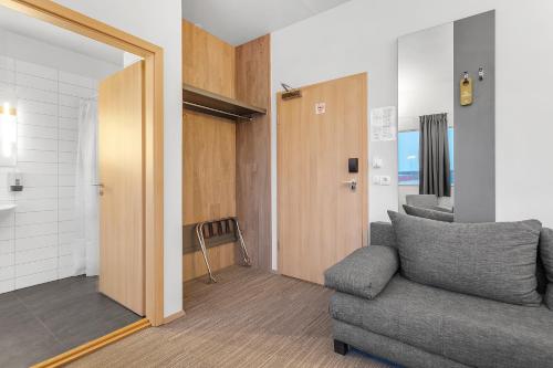 a living room with a couch and a bathroom at Hotel Vellir in Hafnarfjördur