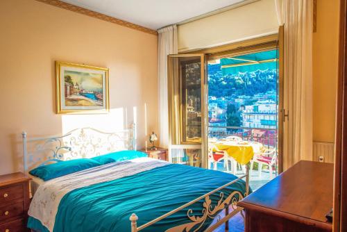 een slaapkamer met een bed, een tafel en een raam bij [MARI E MONTI] Appartamento in centro in Rapallo