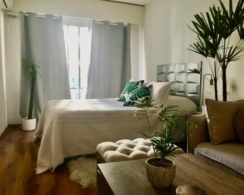 1 dormitorio con 1 cama y 1 sofá en Loft con piscina en Punta Carretas, en Montevideo
