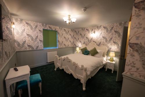 a bedroom with a white bed and pink wallpaper at Kip 23 JJs Emsworth in Emsworth