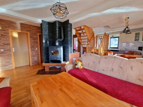 een woonkamer met een bank en een open haard bij Snowman Apartments in Kupres