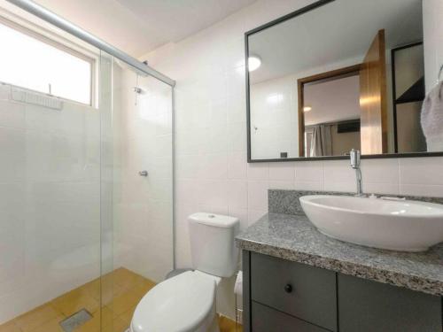 a bathroom with a sink and a toilet and a mirror at Apartamento Funcional Melhor Maringá! - SQ33 in Maringá