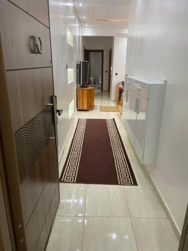 um corredor com uma porta e um tapete no chão em Appartement avec suite parentale em Mohammedia