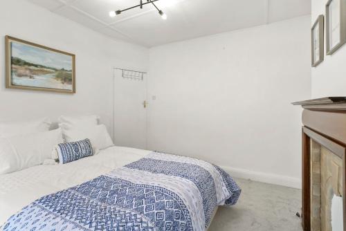 a bedroom with a bed with a blue and white blanket at Wembley Hububb Stay in London