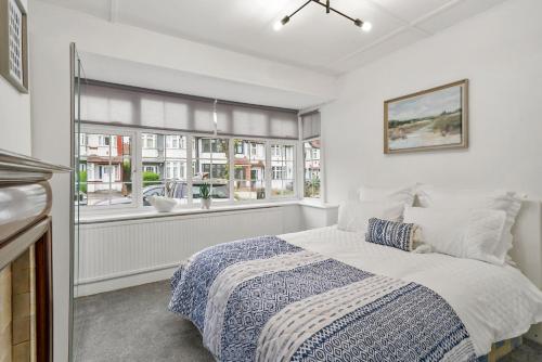 a white bedroom with a bed and a window at Wembley Hububb Stay in London