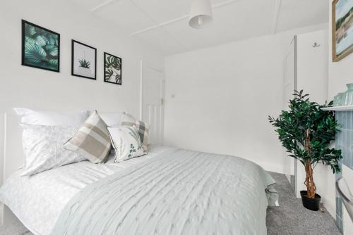 a white bedroom with a large white bed with pillows at Wembley Hububb Stay in London