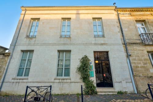 un bâtiment avec un vélo garé devant lui dans l'établissement Villa Erizio, Bordeaux Centre, à Bordeaux