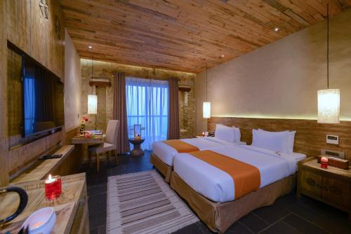 a bedroom with a large bed and a television at Sarangkot Mountain Lodge in Pokhara