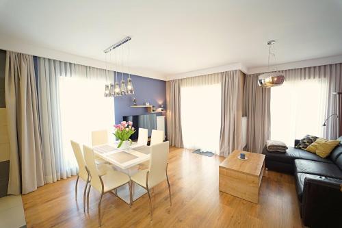 シュクラルスカ・ポレンバにあるApartamenty EverySky - Górna 19Aのテーブルとソファのあるリビングルーム