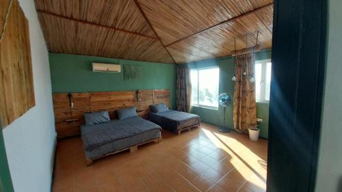 ein Schlafzimmer mit einem Bett und einem Sofa in einem Zimmer in der Unterkunft Bon Vivant Front de Mer - Ile Rodrigues in Rodrigues Island