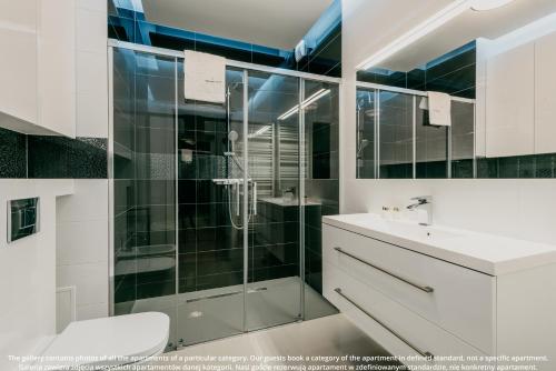 a bathroom with a shower and a toilet and a sink at EXCLUSIVE Aparthotel Kraków Browar Lubicz in Krakow