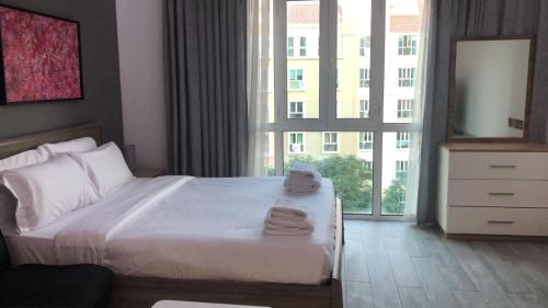 a hotel room with a bed and a large window at Upgraded studio close to Metro in Dubai