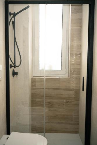 a bathroom with a shower with a toilet and a window at Black Marble - Design Apartment in Bari