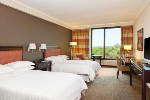 Una habitación de hotel con dos camas y un escritorio. en Sheraton Tucumán Hotel, en San Miguel de Tucumán