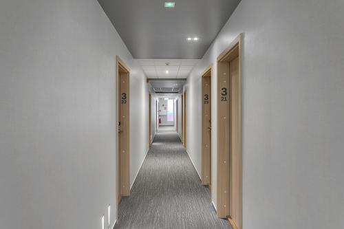 a hallway with white walls and a long hallway with doors at Hotel Vellir in Hafnarfjördur