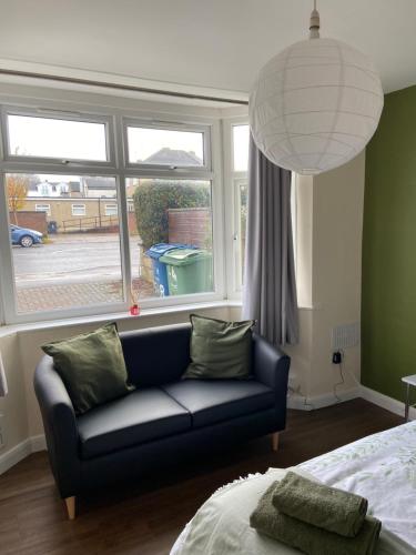 a living room with a couch in front of a window at 2bed apartment free parking in Oxford