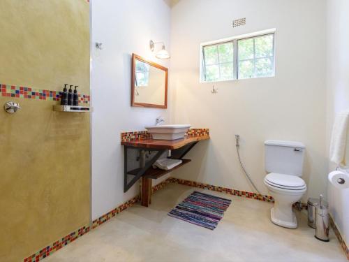 a bathroom with a toilet and a sink and a shower at The Courtney Lodge in Victoria Falls