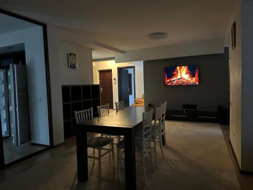 ein Esszimmer mit einem Tisch und Stühlen mit einem Feuerbild an der Wand in der Unterkunft Apartment OneClickRent 07 Penthouse in Chişinău