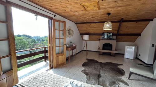 ein Wohnzimmer mit einem Kamin und einer Holzdecke in der Unterkunft Pousada Flor de Lua Monte Verde in Monte Verde