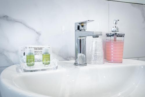 佛羅倫斯的住宿－Residenza24，浴室水槽配有水龙头和两杯玻璃杯