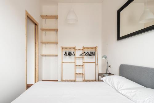 Un dormitorio con una cama blanca y una escalera en AirLoft 3 confort vicino a Rho Fiera, en Rho