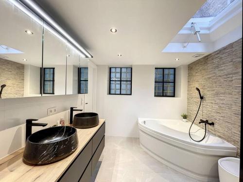 een badkamer met een groot bad en een grote wastafel bij Maison Ker Armor - De Panne in De Panne