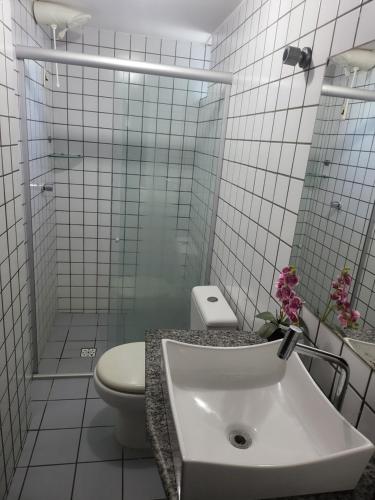 uma casa de banho branca com um WC e um lavatório em Apartamento 3 quartos beira mar Intermares-Cabedelo VALOR DA TAXA DE LIMPEZA E DO AR CONDICIONADO COBRADO À PARTE em Cabedelo