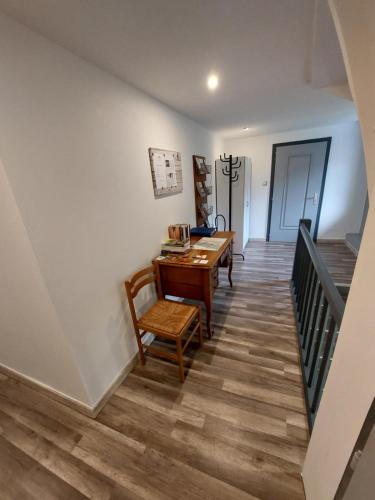 a dining room with a table and chairs and a staircase at Gite en pleine verdure au coeur du village in Lapoutroie