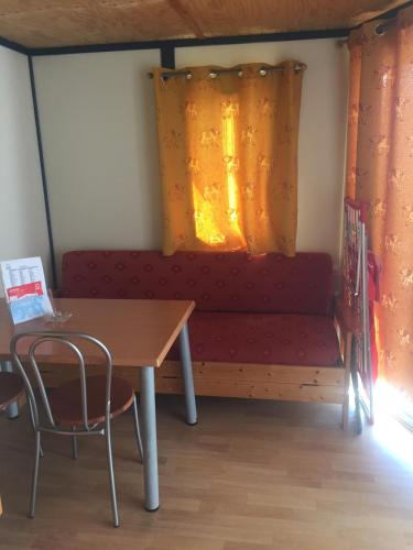 a room with a table and a bench with a window at Orbitur Ilha de Armona in Olhão