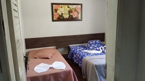 um quarto com duas camas e uma foto na parede em POUSADA FLOR DO IPÊ em Juazeiro do Norte
