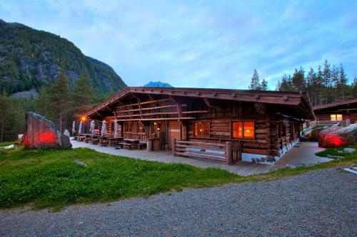 a log cabin with tables and chairs in front of it at Aktivhotel Waldhof in Oetz