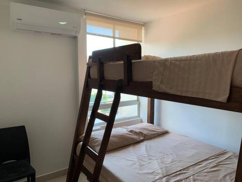 um quarto com 2 beliches e uma janela em apartamento en peñazul aldea em Ricaurte