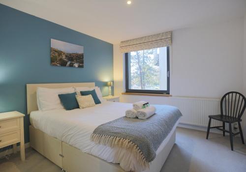 1 dormitorio con 1 cama con silla y ventana en The East London Residence, en Edimburgo