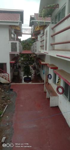 an alley between two buildings with a red sidewalk at Hotel Five Laurels in Yercaud
