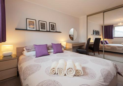 sypialnia z łóżkiem z ręcznikami w obiekcie Logie Green Road Apartment w Edynburgu