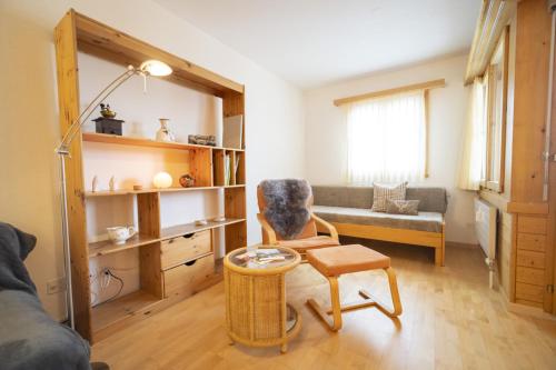 a living room with a chair and a couch at Chasa Trais Fluors in Scuol